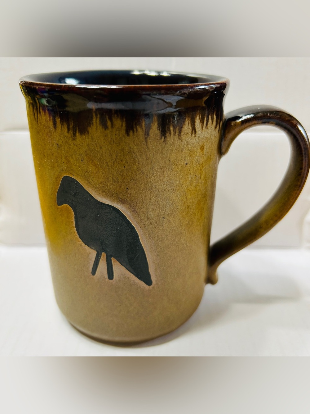 Coffee mug with black crow, light brown with dark brown drip glaze. NWT.
